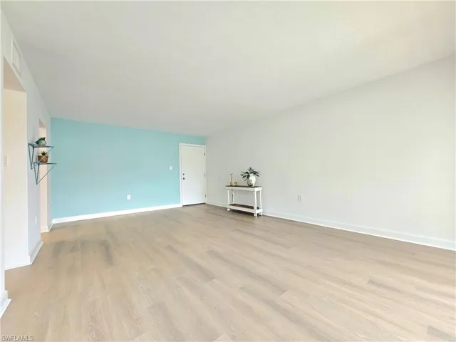 Empty room with light wood finished floors and baseboards
