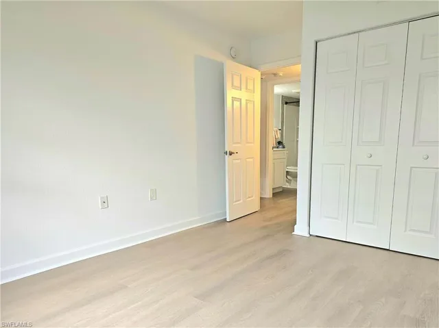 Unfurnished bedroom with light wood-style floors and a closet