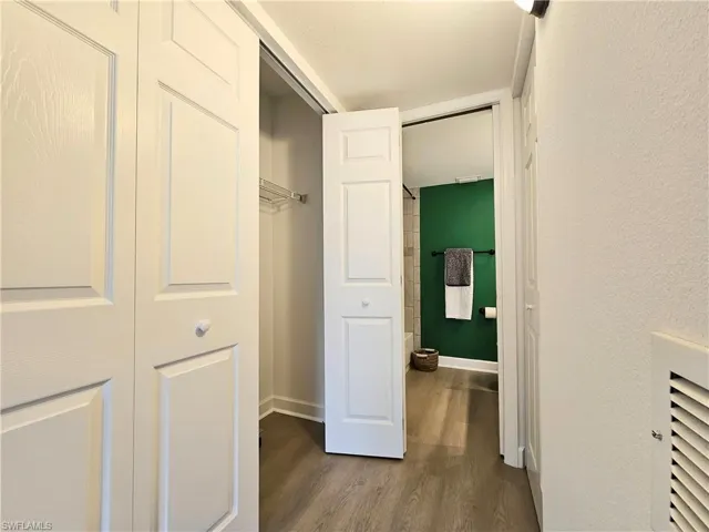 Hall featuring dark wood-type flooring and baseboards