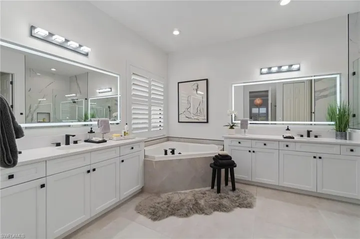 Bathroom featuring a marble finish shower, a bath, two vanities, tile patterned flooring, and recessed lighting