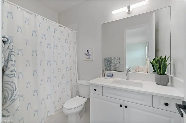 Full bath featuring vanity, curtained shower, and tile patterned flooring
