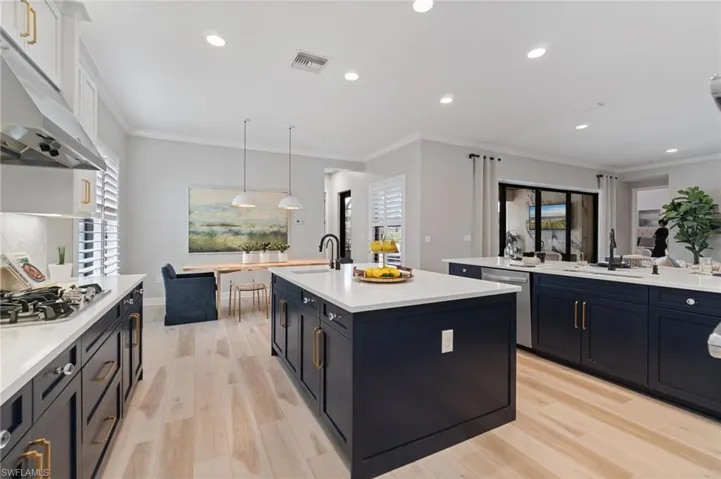 Timeless style is infused with deep navy contrasting lower cabinetry offset by crisp white quartz and sparkling golden hardware in the expansive open kitchen floorplan!
