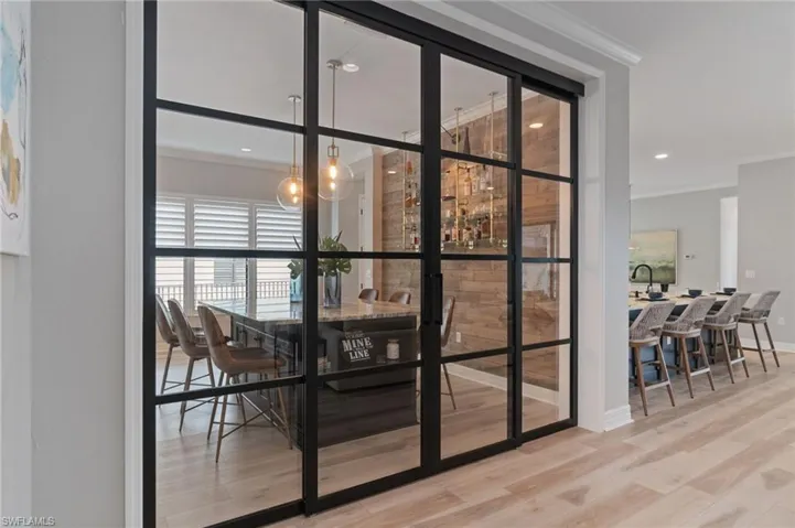 Conversation worthy modern metal privacy doors leading into the formal dining room.  Beautifully customized with feature wine and liquor walls.
