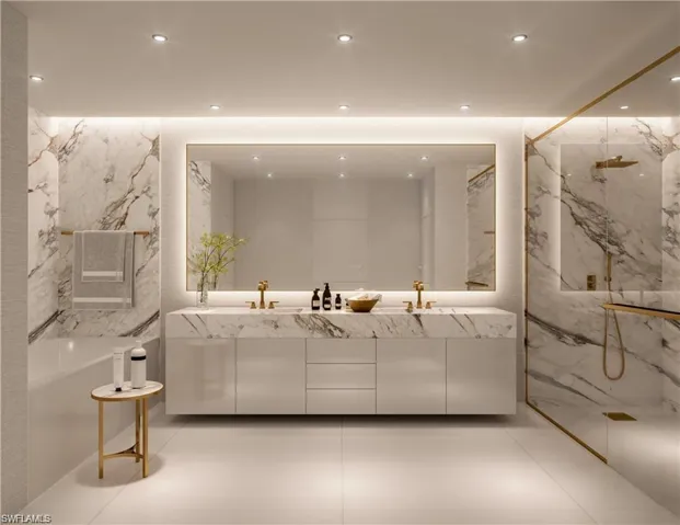 Bathroom with double vanity, a marble finish shower, stone wall, a freestanding tub, and recessed lighting