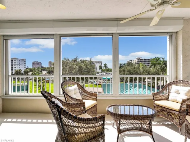 Enclosed balcony featuring tile flooring, ceiling fan, and white railing