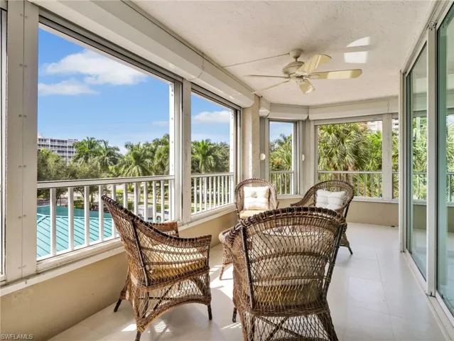 Large windows, neutral tile flooring, white cabinetry, decorative pendant light fixture, and glass-paned exterior door