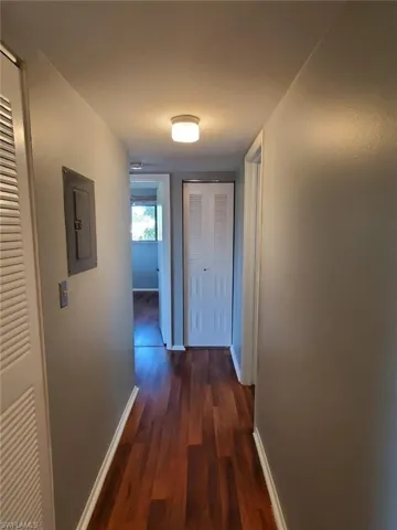 Hall featuring dark wood-type flooring and electric panel