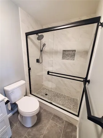 Full bath with a shower stall and vanity