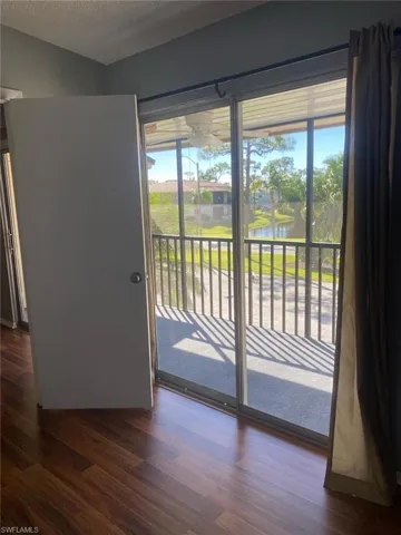 Entryway with a water view, wood finished floors, and a textured ceiling
