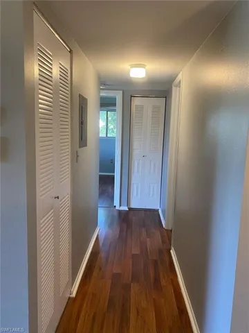 Hallway with dark wood-style flooring and electric panel