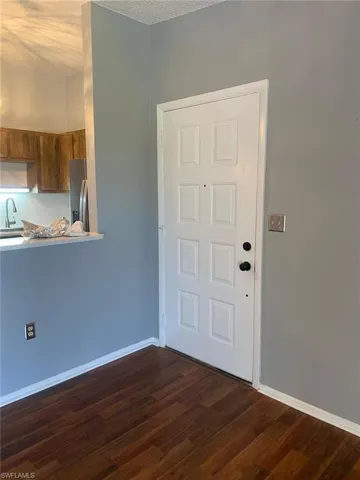 Foyer with dark wood-style flooring and a textured ceiling