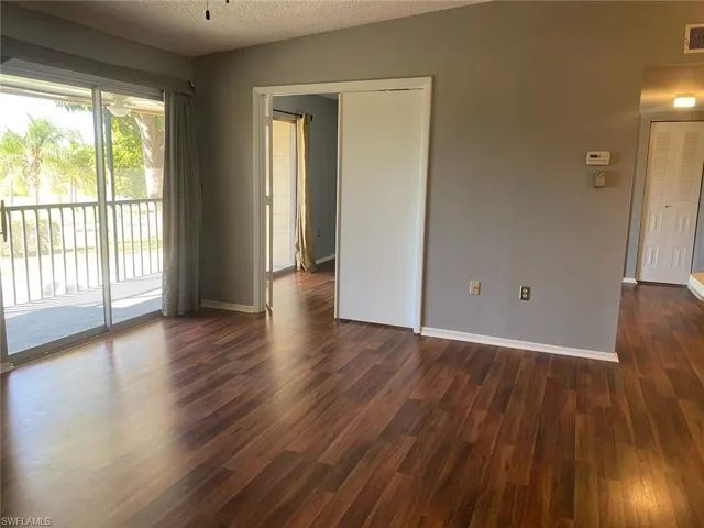 Spare room featuring dark wood-style flooring and a textured ceiling