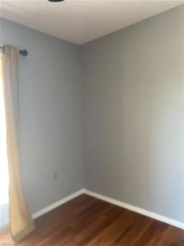 Spare room with dark wood-style flooring