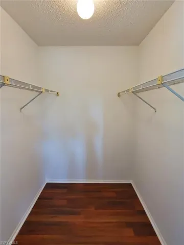 Walk in closet featuring dark wood finished floors