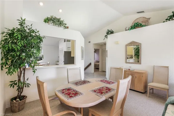Dining space featuring lofted ceiling and light colored carpet