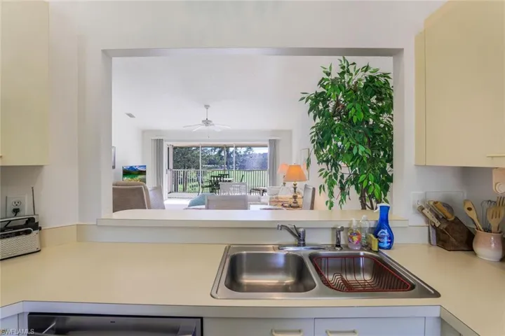 Kitchen with light countertops, ceiling fan, cream cabinetry, and open floor plan