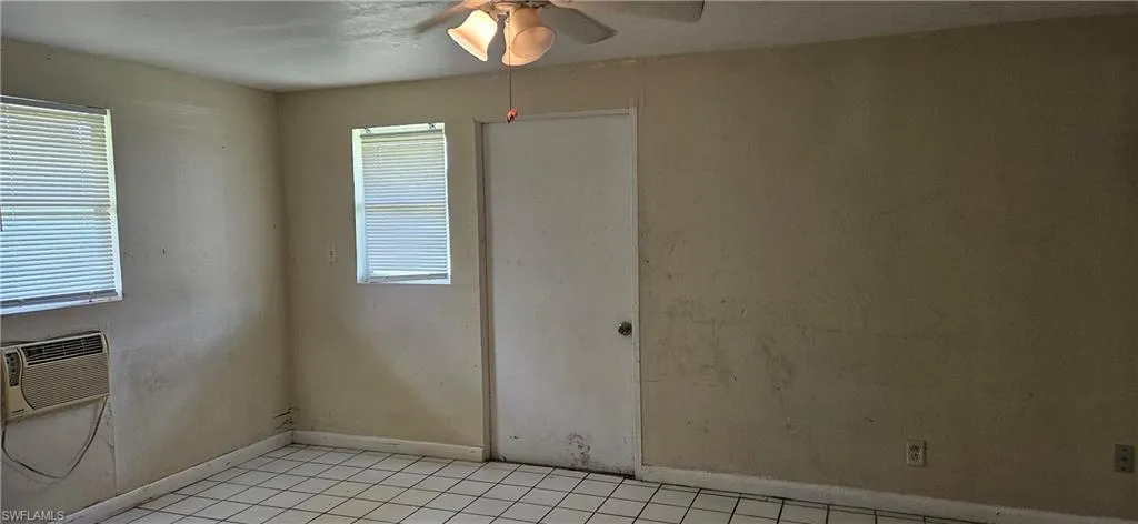 Spare room with ceiling fan, light tile patterned flooring, and a healthy amount of sunlight