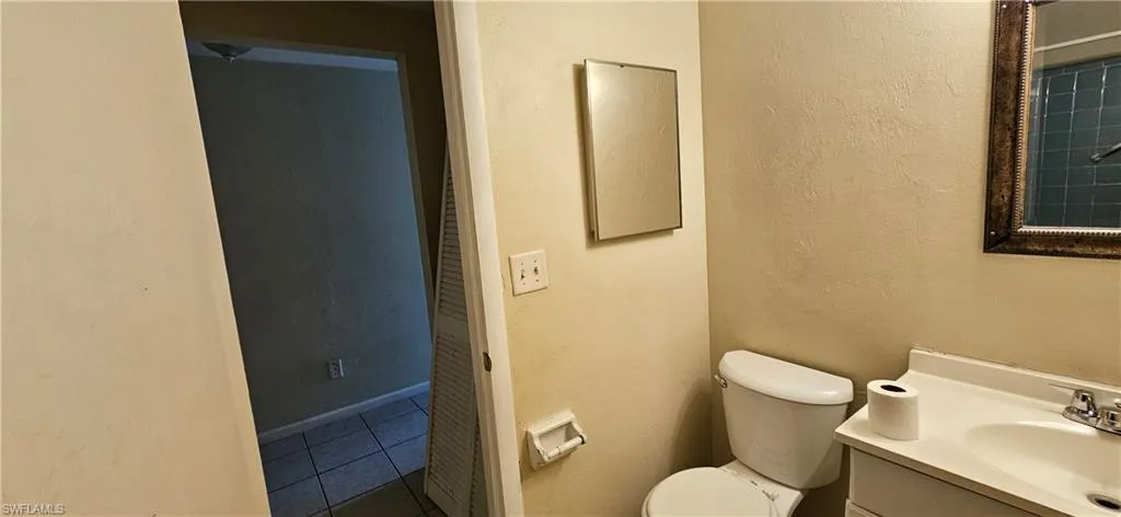 Bathroom with tile patterned flooring, vanity, and toilet