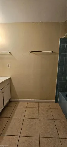 Bathroom with vanity, shower / washtub combination, and tile patterned floors