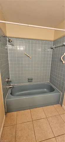 Bathroom with tiled shower / bath and tile patterned floors