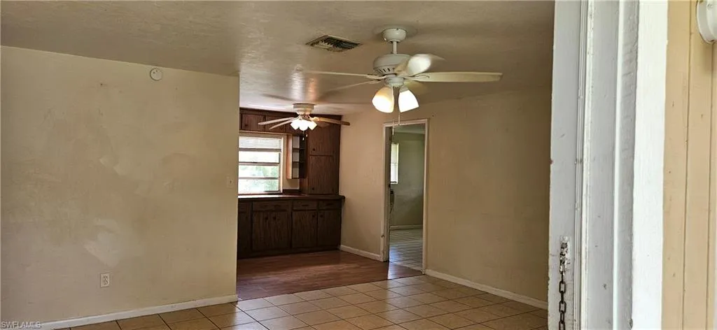 Tiled spare room featuring ceiling fan