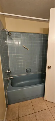 Bathroom with tile patterned flooring and tiled shower / bath combo