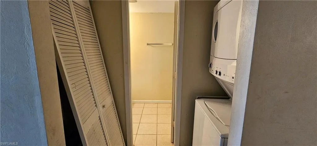 Bathroom with stacked washer / dryer and tile patterned flooring