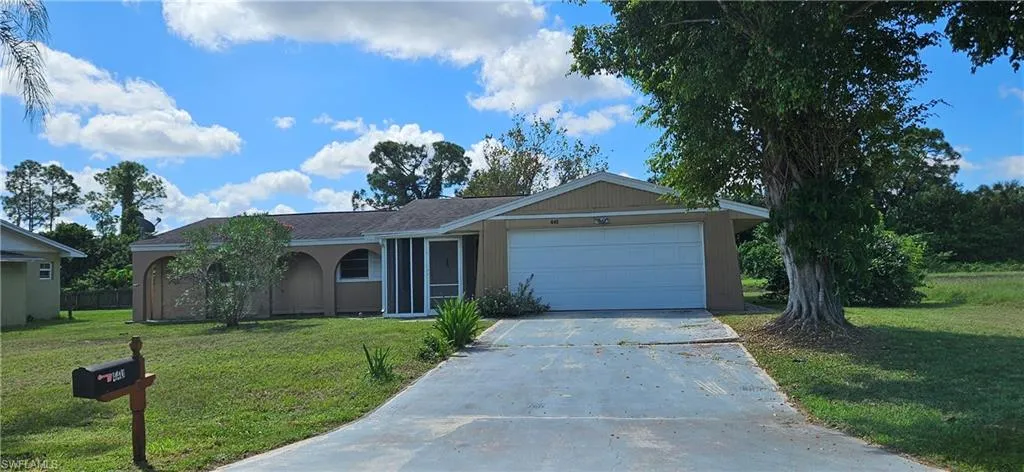 Ranch-style house with a front yard and a garage
