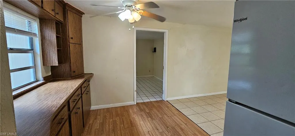 Kitchen featuring light wood-type flooring, ceiling fan, and stainless steel refrigerator