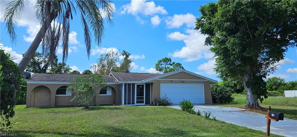 Ranch-style home with a front yard and a garage