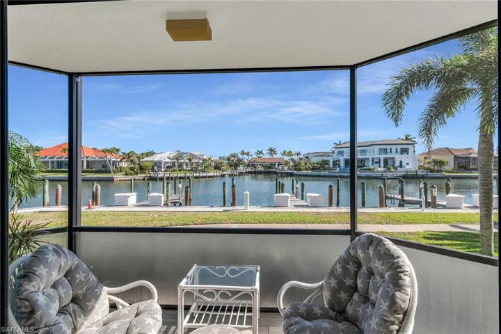 Sunroom featuring a residential view and a water view