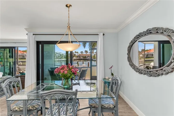 Dining room featuring light wood-type flooring, baseboards, and ornamental molding