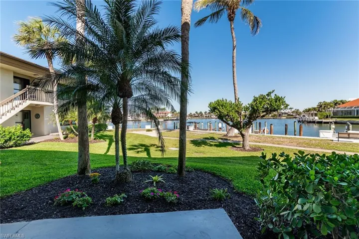View of property's community with a water view and a lawn