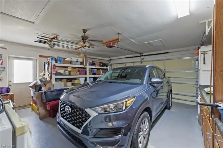 Garage with a garage door opener and a ceiling fan