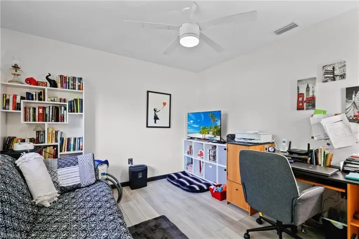 Office with light wood-style flooring and a ceiling fan