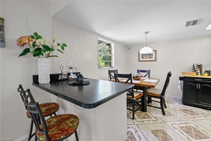 Dining area with light tile patterned floors and wooden walls