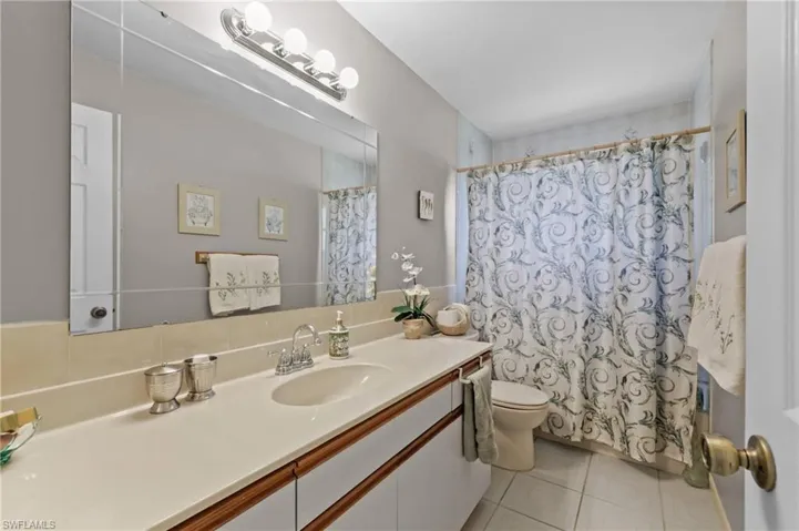Full bath featuring toilet, tile patterned flooring, vanity, and a shower with shower curtain