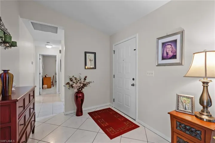 Foyer entrance featuring light tile patterned flooring and baseboards