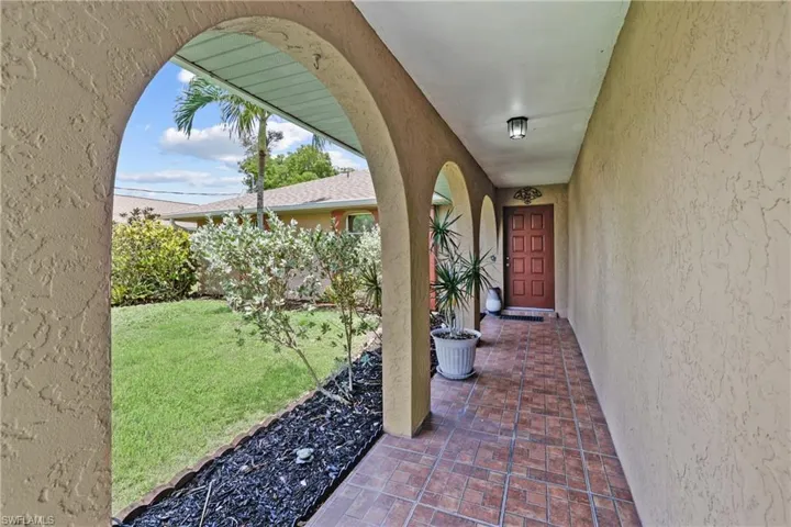 Property entrance with stucco siding and a yard