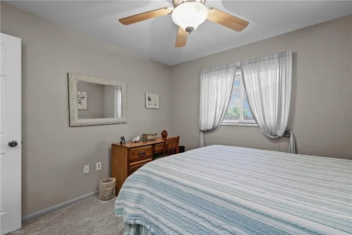 Carpeted bedroom with baseboards and a ceiling fan