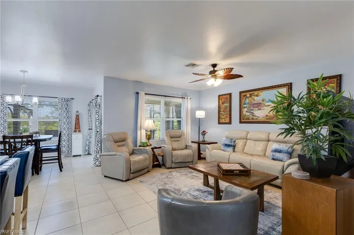 Living room with light tile patterned floors and ceiling fan