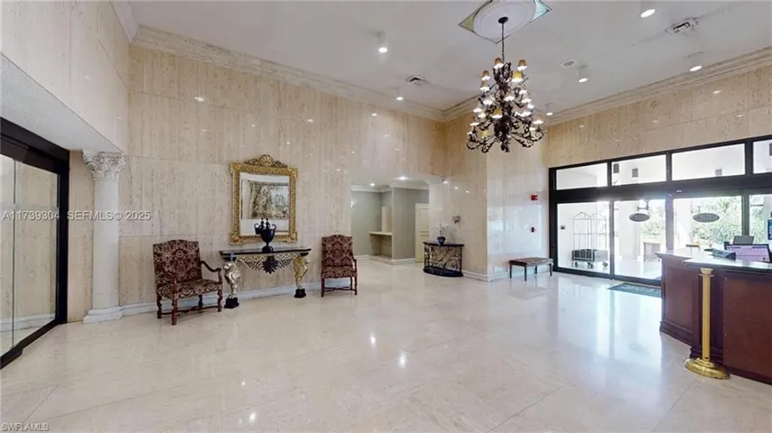 Grand foyer featuring polished stone flooring and wall finishes