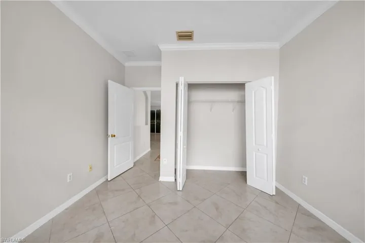 Unfurnished bedroom with ornamental molding and a closet