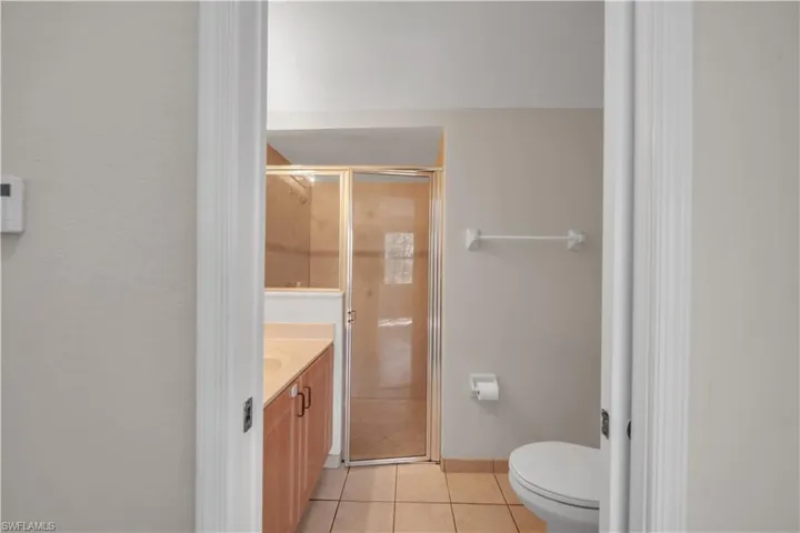 Full bath featuring vanity, a shower stall, and light tile patterned floors