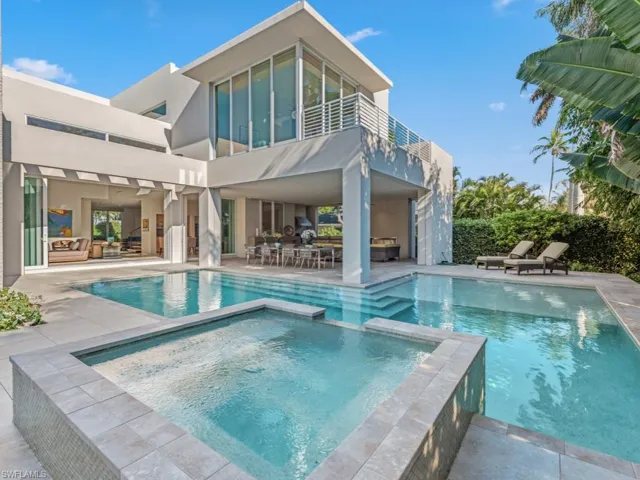 View of back of home, pool and spa