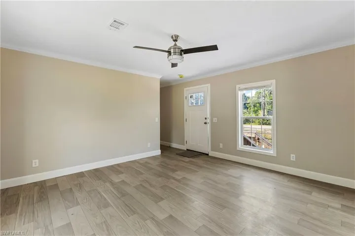 Unfurnished room with ceiling fan, light hardwood / wood-style floors, and crown molding