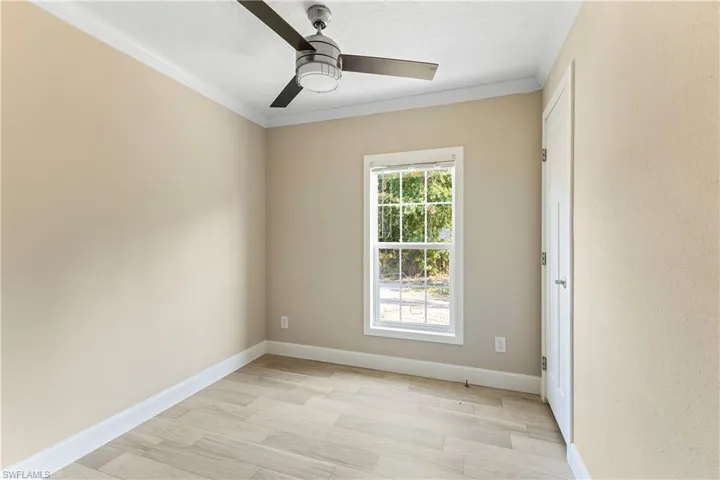 Bedroom 3 featuring light wood-type flooring, crown molding, and ceiling fan