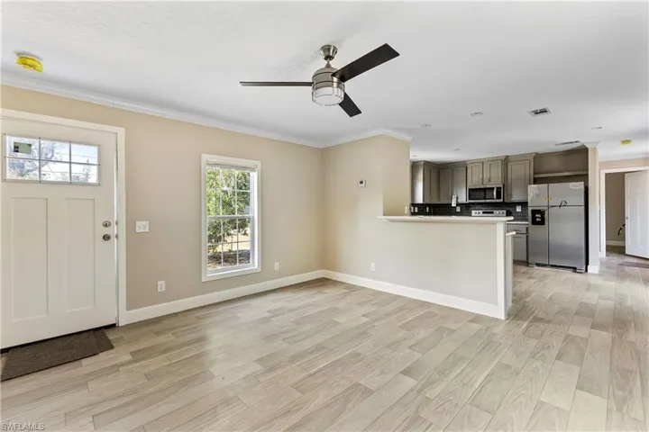 Kitchen featuring ceiling fan, light hardwood / wood-style floors, kitchen peninsula, tasteful backsplash, and stainless steel appliances