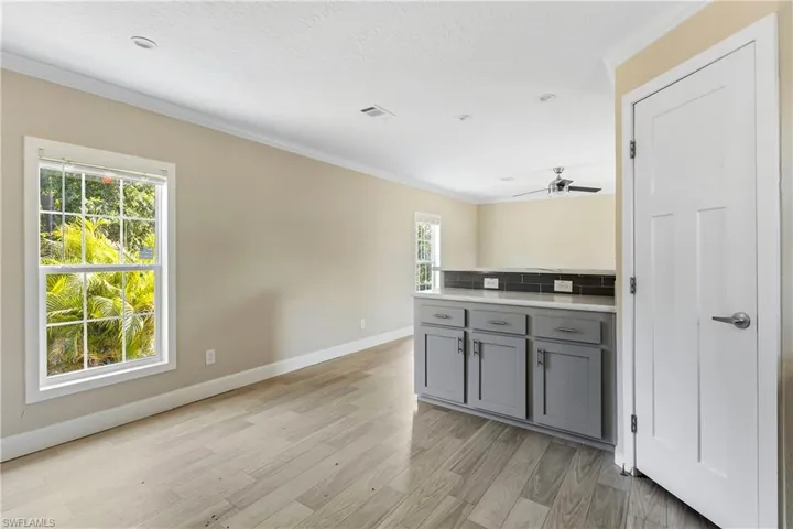 Kitchen with backsplash, ceiling fan, light hardwood / wood-style floors, and crown molding