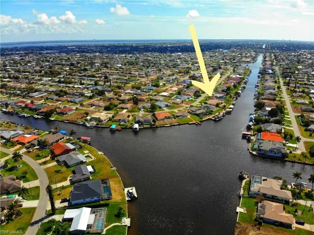 Aerial view of property and surrounding area with a nearby body of water and nearby suburban area